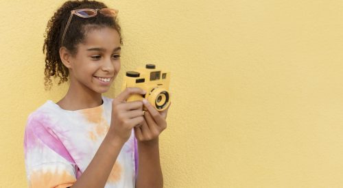 smiley-girl-holding-camera-coup-moyen-500x275